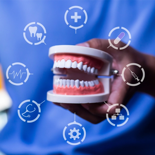 Dental model with teeth held in a hand, surrounded by healthcare and dental care icons.